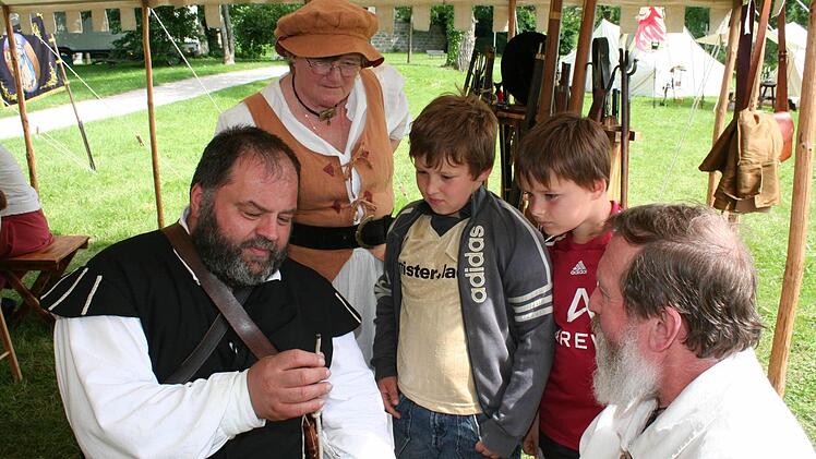 Peter Lorz zeigt Andre und Marek, was eine Lunte ist. Mit im Bild Richard Gebhardt (rechts) und seine Frau Sieglinde (hinten)