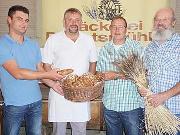 Aus Sondernauer und Weisbacher Urgetreide wird in Bischofsheim Ackerritterbrot und Urspitz. Die drei Landwirte Michael Tulit (links), Peter Friedrich (Zweiter von rechts) und Rudolf Wappes (rechts) bauen die Urgetreide Emmer, Waldstaudenroggen und Dinkel an. Bäckermeister Manfred Enders von der Degetsmühle hat nach längerem Tüfteln die beiden Vollkornprodukte kreiert. Foto: Marion Eckert