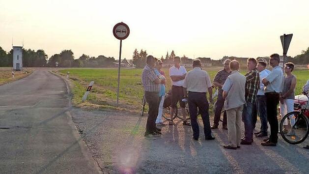 Die Mitglieder des Bauausschusses trafen sich an der Stra&szlig;e (links), die bei Hochwasser &uuml;berschwemmt wird. Foto: Pauline Lindner