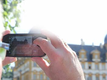 Ein Tourist fotografiert das Schloss Seehof in Memmelsdorf. Foto: Michael Gründel/Archiv
