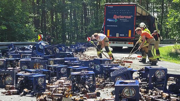 Viele Bierk&auml;sten lagen nach dem Unfall auf der Staatsstra&szlig;e, auf der sich ein Scherbenmeer gebildet hatte.