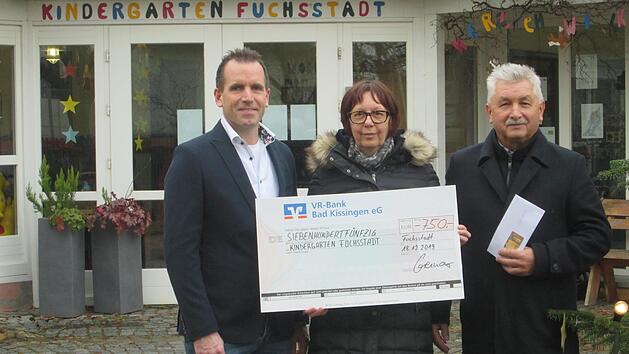 Die Weihnachts&uuml;berraschung f&uuml;r den Kindergarten Fuchsstadt &uuml;bergaben Ren&eacute; Gerner (links) und B&uuml;rgermeister Peter Hart (rechts) an die Stellvertretende Leiterin Petra Hamak.  Foto: Winfried Ehling