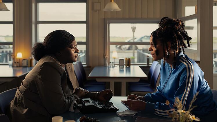 Gloria Acheampong (Thelma Buabeng, links) spricht mit Zeugin Mercy (Jane Chirwa), die ein Caf&eacute; betreibt.