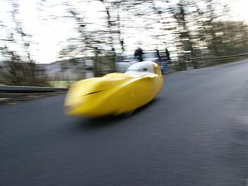 Ein Velomobil rauscht den Hügel auf der Ortsverbindungsstraße von Elfershausen nach Aura runter. Fotos: Arkadius Guzy