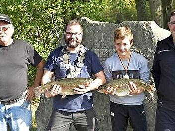 Eingerahmt vom Vorsitzenden des Anglervereins Königsberg, Thomas Strobel (links), und seinem Stellvertreter Alexander Strobel (rechts) zeigen der neue Junganglerkönig Janik Müller und Anglerkönig Markus Pätzold ihre gefangenen Forellen.  Foto: Gerold Snater