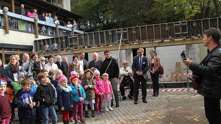Begleitet von Pfarrer Daniel Steffen Schwarz (r.) auf der Gitarre erfreuten die Mädchen und Jungen des Kindergartens die Besucher des Richtfestes. Foto: Gerda Völk