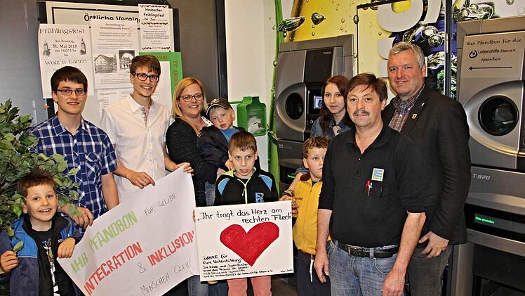 Das "Herz am rechten Fleck" tragen alle Spenderinnen und Spender, die ihre Pfandbons in die grüne Box (hinten Mitte) werfen. Über den Erlös freuen sich (von links): Bircau, Lukas Middelstaedt, Dominik Baum, Isabel Kuhn, Leon, Fabian, Paul, Praktikantin Dorothea, Klaus Rother und Bürgermeister Jürgen Hennemann. Foto: Helmut Will