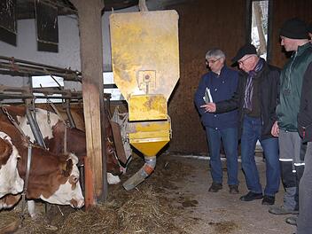 Das Kraftfutter kommt im Rosenbauer-Stall computergesteuert per Automat: Hans Rebelein, Gerhard Ehrlich sowie Markus und Helmut Rosenbauer diskutieren über die Zukunftsfähigkeit eines Stalles mit 30 Milchkühen. Foto: Berthold Köhler