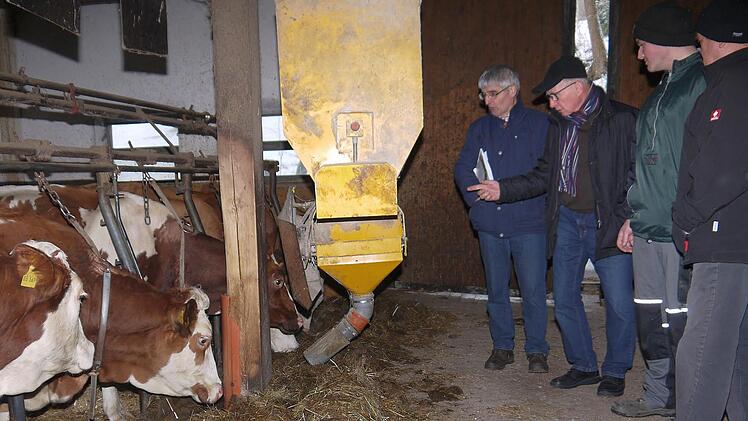 Das Kraftfutter kommt im Rosenbauer-Stall computergesteuert per Automat: Hans Rebelein, Gerhard Ehrlich sowie Markus und Helmut Rosenbauer diskutieren über die Zukunftsfähigkeit eines Stalles mit 30 Milchkühen. Foto: Berthold Köhler