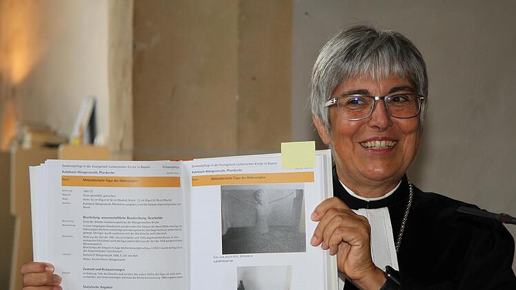 Auf der Empore ist eine halbe Figur des Gekreuzigten zu sehen, zeigte Regionalbischöfin in dem Inventarbuch der Mangersreuther Kirche und verwies auf die Liebenswürdigkeit und Lebendigkeit des Unperfekten.