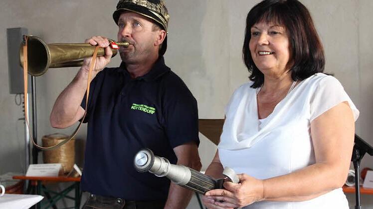 Kommandant Alfons Griebel, in dessen Familie seit vielen Jahren Hornisten für die Feuerwehr bliesen, gab auf einer alten "Feuerwehrtute" das Startsignal für die Veranstaltung. Bürgermeisterin Gertrud Bühl hält ein Strahlrohr aus dem Feuerwehrmuseum Mechenried in Händen. Foto: Helmut Will