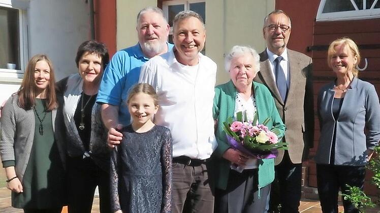 Fototermin im frühlingshaften Garten: Schwiegertochter Tanja, Tochter Martina, Sohn Günter, Enkelin Ella, Sohn Michael, Anna Thyzel (mit Blumenstrauß), Bürgermeister Jürgen Kohmann und Ortssprecherin Bärbel Köcheler Foto: Monika Schütz