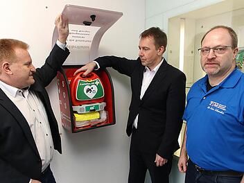 Einen Defibrillator im Vorraum der Raiffeisenbank Maßbach nahmen  Bürgermeister Matthias Klement, Bankvorstand Michael Hein und Jürgen Müller  vom Zentrum Telemedizin Bad Kissingen in Betrieb. Auch in den anderen drei  Ortsteilen wurden Geräte angebracht. Foto: Dieter Britz