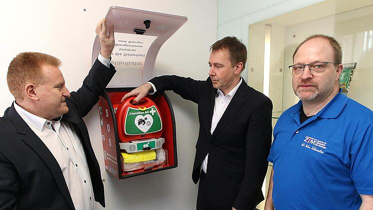Einen Defibrillator im Vorraum der Raiffeisenbank Maßbach nahmen  Bürgermeister Matthias Klement, Bankvorstand Michael Hein und Jürgen Müller  vom Zentrum Telemedizin Bad Kissingen in Betrieb. Auch in den anderen drei  Ortsteilen wurden Geräte angebracht. Foto: Dieter Britz