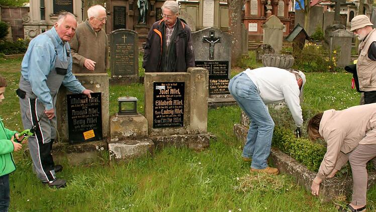 Gerd Schindelmann, Werner Eberth und Gerhard Wulz (von links) und Helfer kümmern sich um Verschönerungen im Kapellenfriedhof, Foto: Vogel