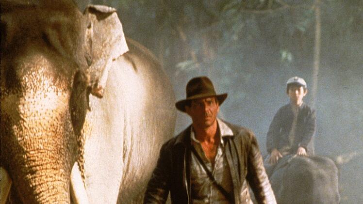 Auf Elefanten machen sich Indy (Harrison Ford, links) und Shorty (Jonathan Ke Quan) auf den Weg zum Palast des Maharadschas von Pankot.