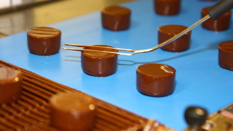 Mit einer langzinkigen Gabel erhalten die überzogenen Pralinen ein Muster.