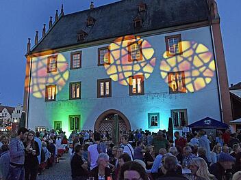 Lichtspiele sorgten für ein zauberhaftes Ambiente beim vierten Marktplatzfest in Haßfurt. Hier schlage das Herz der fränkischen Stadt, meint Bürgermeister Günther Werner. Die Besucher saßen am alten Rathaus, das plötzlich ein bisschen anders aussah ... Foto: Ulrike Langer