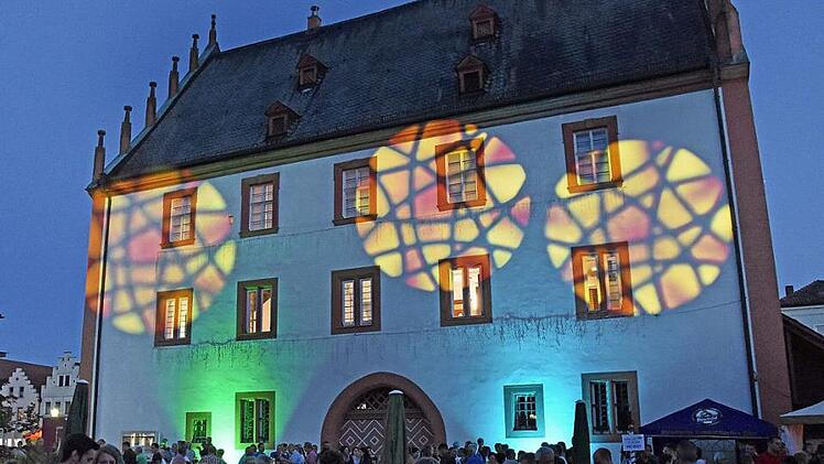 Lichtspiele sorgten für ein zauberhaftes Ambiente beim vierten Marktplatzfest in Haßfurt. Hier schlage das Herz der fränkischen Stadt, meint Bürgermeister Günther Werner. Die Besucher saßen am alten Rathaus, das plötzlich ein bisschen anders aussah ... Foto: Ulrike Langer