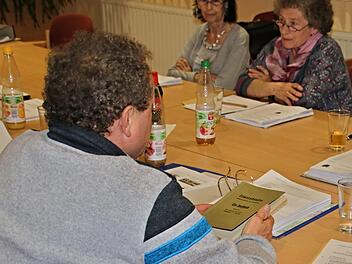 Zweitem Bürgermeister Klaus Welz über die Schulter geblickt: Er hält das Dorfbuch von Ermershausen in der Hand, das eventuell zum 975-jährigen Bestehen der Gemeinde neu aufgelegt werden soll. Ihm gegenüber sitzen die Gemeinderätinnen Lydia Steuter (FW) und Gertrud Pößnecker (FW).Helmut Will