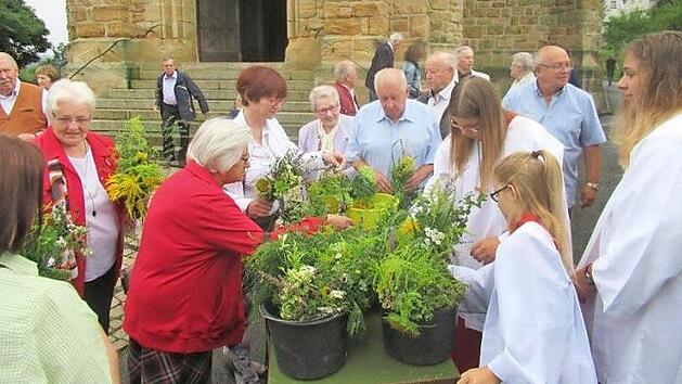 Vor der Kirche wurden Kr&auml;uter und Blumen an die Gottesdienstbesucher ausgegeben.  Foto: Horst Habermann