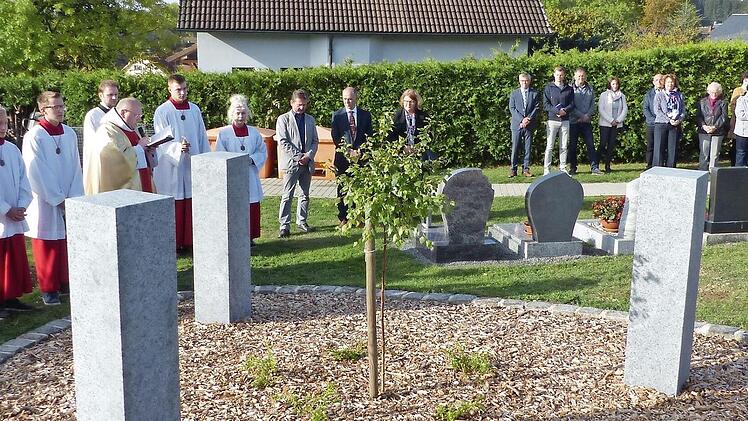 Pfarrer Pater Adrian Manderla weihte im Beisein einer stattlichen Anzahl von Gläubigen die drei Urnenstelen auf dem Hohenberger Gottesacker.  Foto: Klaus-Peter Wulf