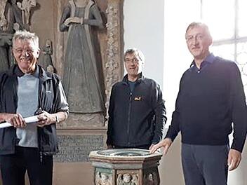 Herbert Müller, Wilhelm Keim, und Pfarrer Gerald Munzert (von links) präsentieren den restaurierten Taufstein.  Foto: privat