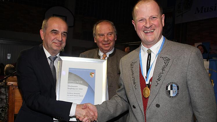 Der Vorsitzende des Musikvereins, Martin Sack (rechts) bekam vom Bezirksvorsitzenden des Nordbayerischen Musikbundes Thomas Kolb und vom Kreisvorsitzenden Heinrich Ramming die Goldene Medaille am weiß-blauen Band. Foto: Sonny Adam