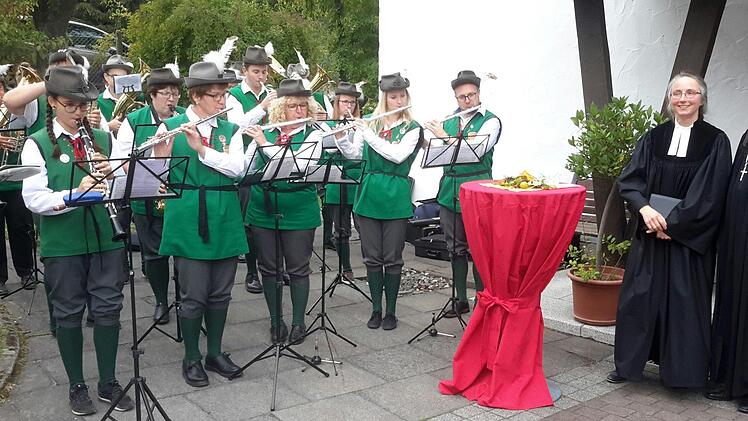 Ein Ständchen spielte der Musikzug Wildflecken zur Verabschiedung von Pfarrerin Daniele Roth (2. von rechts). Zuvor war die Geistliche in einem eindrucksvollen Gottesdienst in der Kreuzkirche von Dekan Till Roth (ganz rechts) entpflichtet worden. Die 51-Jährige wechselt Anfang Oktober nach Deggendorf.Foto: Rolf Pralle