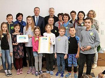 Das "Fairtrade-Team" der Grundschule Eltmann und seine Unterstützer mit der offiziellen Urkunde . Fotos: Günter Geiling