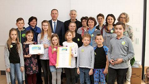 Das "Fairtrade-Team" der Grundschule Eltmann und seine Unterstützer mit der offiziellen Urkunde . Fotos: Günter Geiling