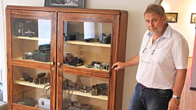 Steffen Schanz vor einer Vitrine mit historischen Fotoapparaten, die ebenfalls Teil der Ausstellung in der Xaver-Mayr-Galerie sind.  Foto: Helmut Will