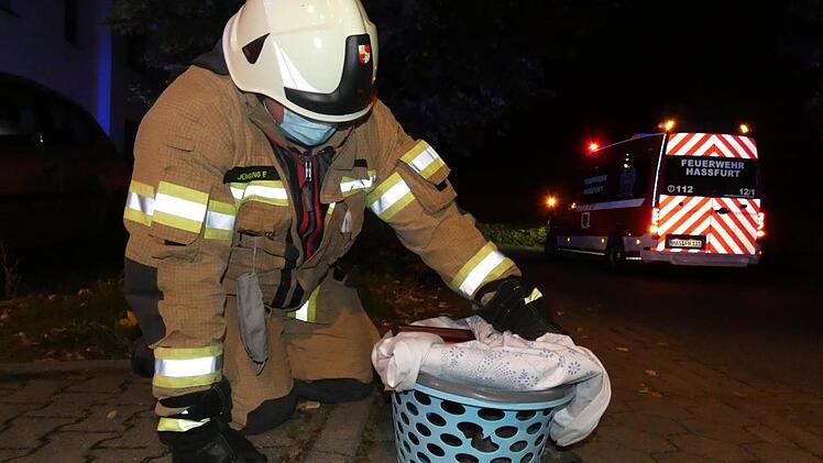 Die Feuerwehr rettete eine Katze aus der verrauchten Wohnung und betreute sie in einem Korb mit provisorischer Abdeckung während des Einsatzes.