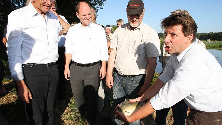 Der Leiter der Bezirks-Fischereifachberatung, Thomas Speierl (r.), inspiziert den Probefang aus den Haider Weihern. Foto: Mathias Erlwein