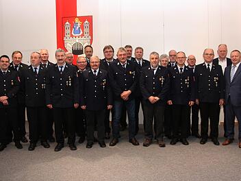 Landrat Thomas Bold (re.) und Bürgermeister Helmut Blank (2.v.e)sowie Kreisbrandmeister Andreas Klopf (links) und Kreisbrandrat Benno Meth (2.v.l) mit den Männern, die seit 40 Jahren der Münnerstädter Feuerwehr die Treue halten. Foto: Matthias  Nöth