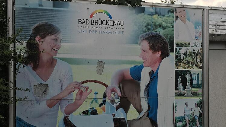 Altes Staatsbad-Logo, rechts oben Mineralwasser-Flasche mit altem Etikett: An der Raststätte Uttrichshausen wirbt die Bad Brückenauer Kurverwaltung mit einem in die Jahre gekommenen und zudem ziemlich schmutzigen Schild fürs Staatsbad. Fotos: Ulrike Müller, Benedikt Borst, Ralf Ruppert