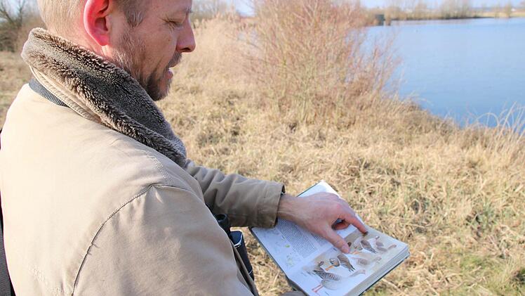 Das Bestimmungsbuch hilft die Vogelarten, die er vor der Linse hat, zuzuordnen.