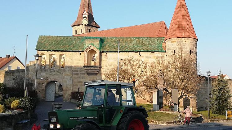 Die Trecker fahren an der Kirchenburg in Effeltrich vorbei ...
