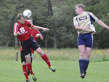 Rafael Brand (links, DJK Schlimpfhof) klärt per Kopf den Angriffsball des Oberbachers Kevin Rüttiger (rechts). Foto: Anja Schmitt
