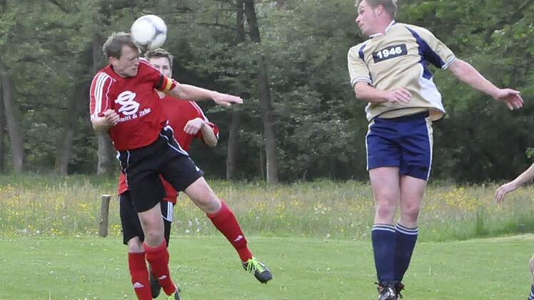 Rafael Brand (links, DJK Schlimpfhof) klärt per Kopf den Angriffsball des Oberbachers Kevin Rüttiger (rechts). Foto: Anja Schmitt