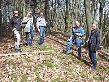 Denkmalpfleger Ralf Obst, 2. Bürgermeisterin Sabine Rießner, Waldbesitzer Rudolf Keller, Forstdirektor Oliver Kröner und Bernhard Christoph blicken hier auf die Steine einer eingestürzten Wallmauer.