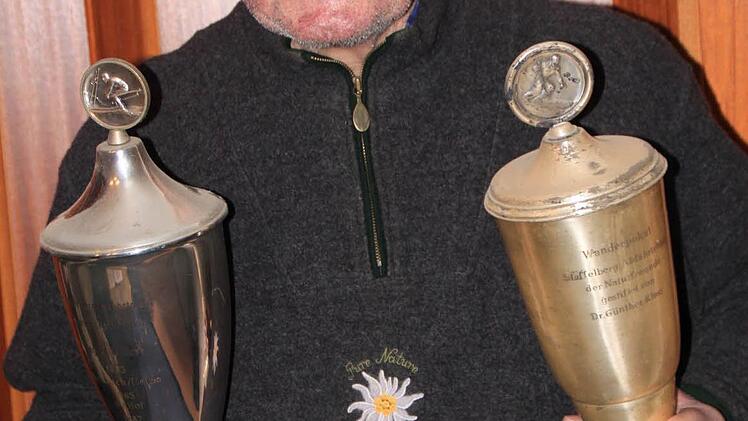 Adam Geuß mit den beiden Pokalen, die ein wenig Patina angesetzt haben. Der 76-Jährige hatte sie in den 1950er Jahren bei Abfahrtsrennen am Staffelberg gewonnen.  Foto: Matthias Einwag