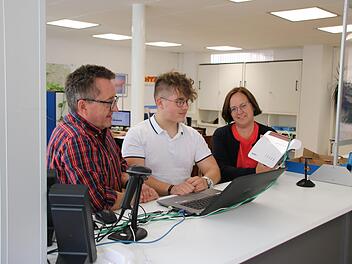 Der 17-jährige Fabian Gröber (Mitte) absolviert bei den Hammelburger Stadtwerken eine Ausbildung zum IT-System-Kaufmann. Hier schauen ihm Betriebsleiter Stephan Dausacker (links) und Geschäftsführerin Anja Binder (rechts) beim Konfigurieren eines Routers über die Schulter. Foto: Ralf Ruppert