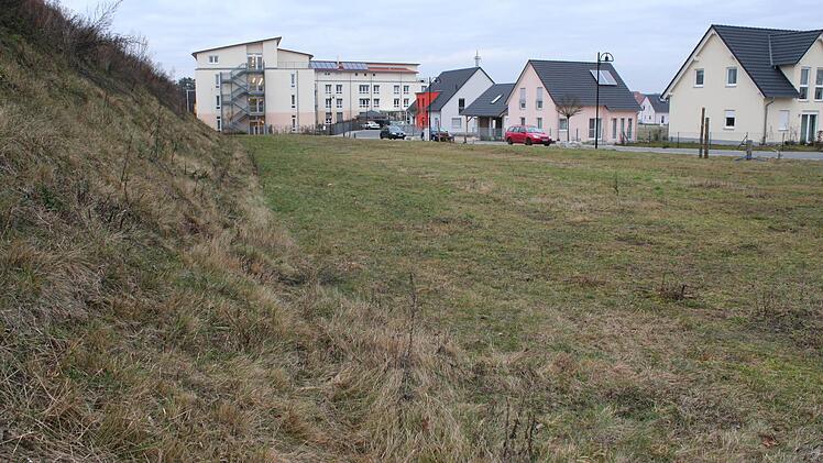 Rechts entlang der Straße soll das Gerätehaus der zusammengelegten Feuerwehren von Hemhofen und Zeckern entstehen. Es soll als Lärmschutz für die Wohnbebauung rechts dienen, dafür soll der Erdwall links verschwinden. Foto: Archiv/Evi Seeger