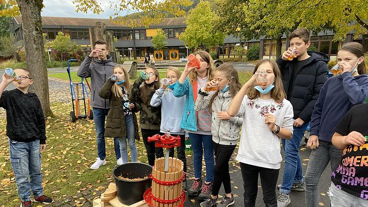 Waschen, pressen, trinken: Der eigenhändig zubereitete frische Apfelsaft schmeckt. Realschul-Direktor Michael Kreil schenkt den Fünftklässlern ein.