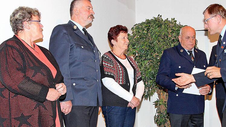 Das Ehrenkreuz in Bronze des Deutschen Feuerwehrverbandes bekamen Gerhard Schreiner (Windheim, l.) und Edmund Wiener (Reichenbach, 2. v. r.), die viele Jahre Kommandanten waren, von Kreisbrandrat Benno Metz (rechts). Mit auf dem Foto sind die Ehefrauen. Foto: Dieter Britz