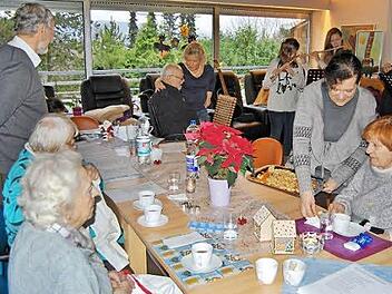 Otto Funck (links), der Organisator des Weihnachtsbackens, sang mit den Senioren bekannte Weihnachtslieder, während Monika Fritz noch am Backofen beschäftigt war.  Foto: Sigismund von Dobschütz