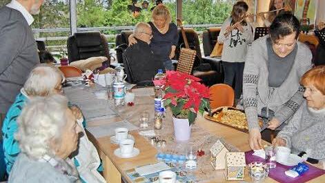 Otto Funck (links), der Organisator des Weihnachtsbackens, sang mit den Senioren bekannte Weihnachtslieder, während Monika Fritz noch am Backofen beschäftigt war.  Foto: Sigismund von Dobschütz