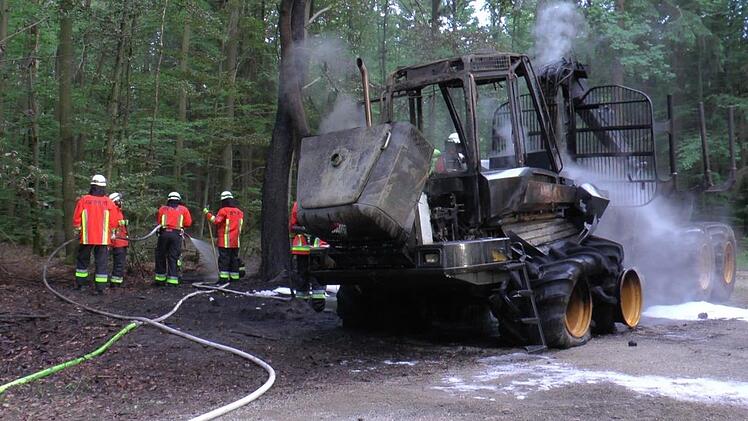 Die Kameraden der Freiwilligen Feuerwehr Fischbach und der Berufsfeuerwehr N?rnberg haben den Brand schnell unter Kontrolle. Jedoch brennt der Harvester komplett aus. Foto: NEWS5 / Friedrich