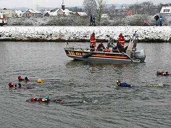 Vom DLRG-Boot begleitet und von Passanten beobachtet, schwammen die zwölf Teilnehmer durch den Main-Donau-Kanal.  Fotos: Werner Baier